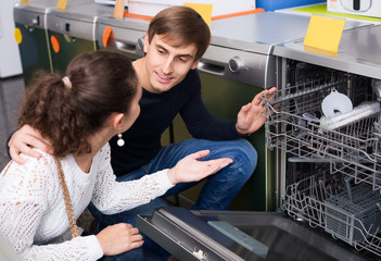  young family couple choosing new dish washing machine in superm