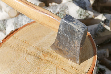 Closeup of axe in a birch log