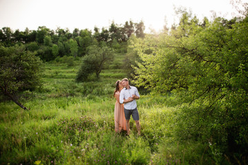 Happy couple in love hugging near green tree and beautiful landscape on background