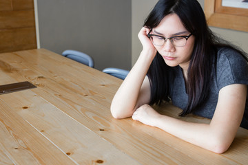 Woman with glasses sleeping on the wooden table