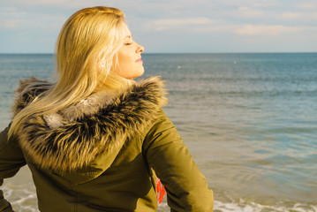 Woman relaxing on beach, cold day