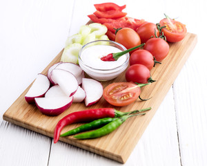 Chopped vegetables served on wooden kitchen board
