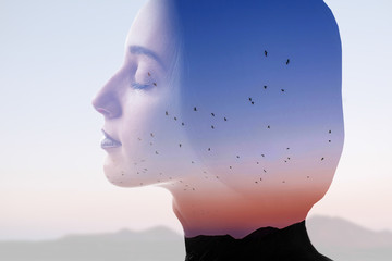 Double exposure photo with woman silhouette and sunset sky with mountains and birds. Freedom and...