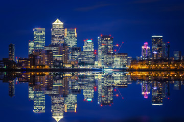 Naklejka premium Canary Wharf business district in London at night over Thames River.