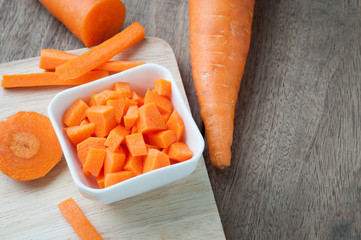 kitchen table with slice fresh carrot on cutting board, selective focus on top view.