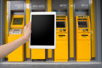 human hand hold  smartphone, tablet, cell phone with blank screen on blurry cash machine.