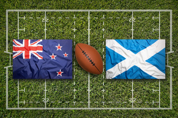 Obraz premium New Zealand vs. Scotland flags on rugby field