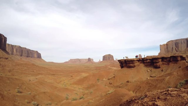 Timelapse view on John Wayne point cliff, between red sand and mountains at a orange desert, in monument valley, in Arizona and Utah border, United states of America