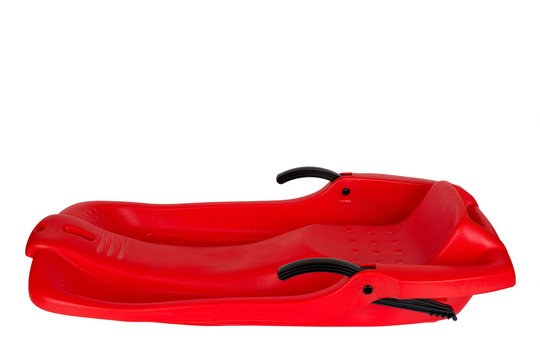 Plastic red sled for skiing on white background