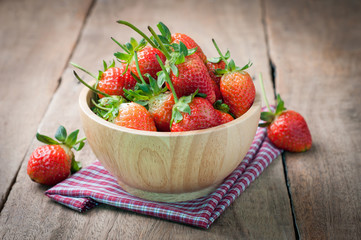 fresh strawberry on wood plate, red tasty fruit on kitchen table. healthy eating and dieting food, concept of health care, Image focus top view.