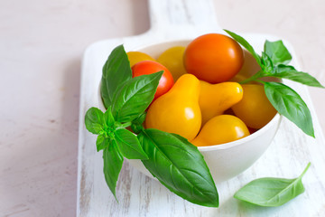  bowl with different cherry tomatoes and basil closeup