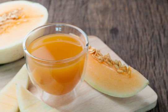 Kitchen table with Glass of cantaloupe melon juice on cutting board. healthy eating and dieting food, concept of health care, Image focus top view.