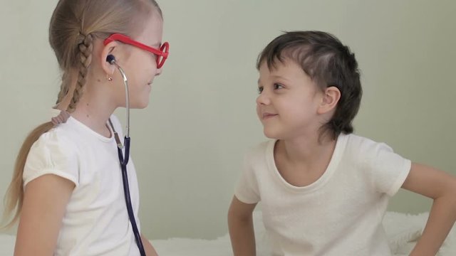 Little doctor examining boy with stethoscope