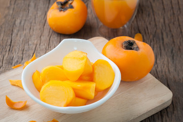 kitchen table with slice fresh persimmon on cutting board , Asian tropical fruit, Image focus top view. healthy eating and dieting food, concept of health care, Image focus top view.