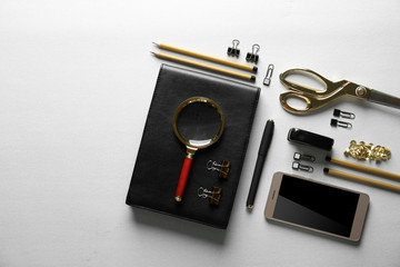 Flat lay of stationery and smart phone on light background