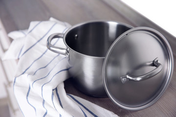 Stainless saucepan on grey kitchen table, closeup