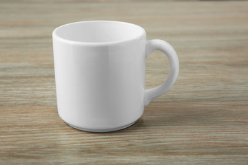 Blank ceramic cup on wooden background