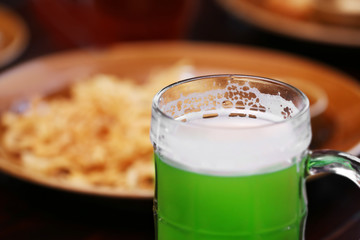 Closeup view of mug with cold beer in pub, on blurred background