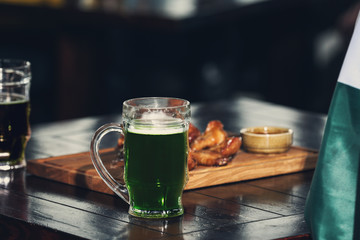 Mug with cold beer on table in pub