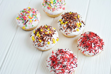 Cupcakes with white cream  and sprinkles on white background