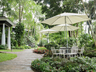 Outdoor table and chair with umbrella  in green garden