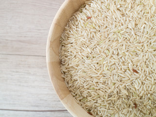 Top view - Close up coarse rice on the wooden plate and on wooden background