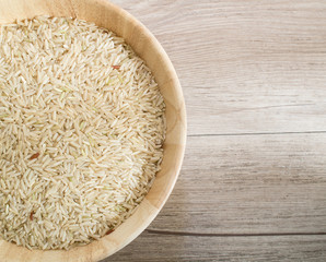 Top view - Close up coarse rice on the wooden plate and on wooden background