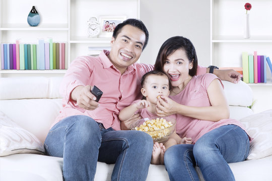 Cheerful family watching TV at home