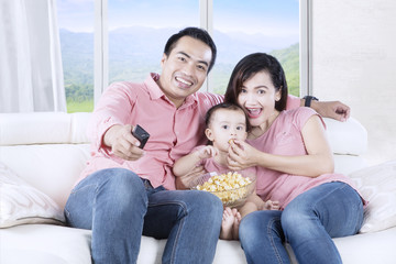 Daughter and parents watching TV