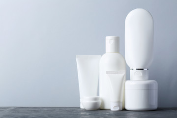 White cosmetic bottles on a grey table