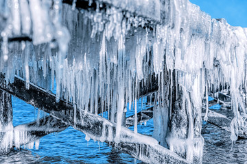 Icicle hanging under jetty roof. Ice, winter.