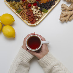 Woman hands holding cup of tea. Top view