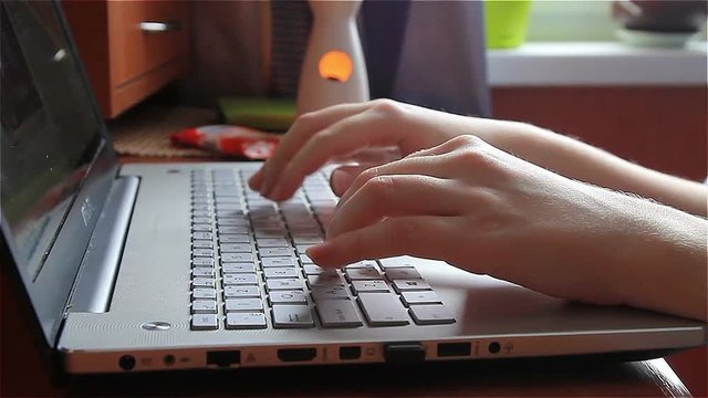 hands of a young woman. using laptop, typing text.
