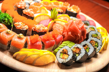 Nigiri sushi and sushi rolls with fish served on wooden table