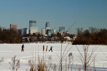Fototapeten Skiing under the Minneapolis Skyline on Lake of the Isles © rasilja