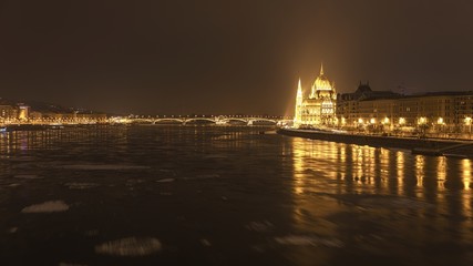 Fototapeta premium Parliament at nighttime with icy Danube