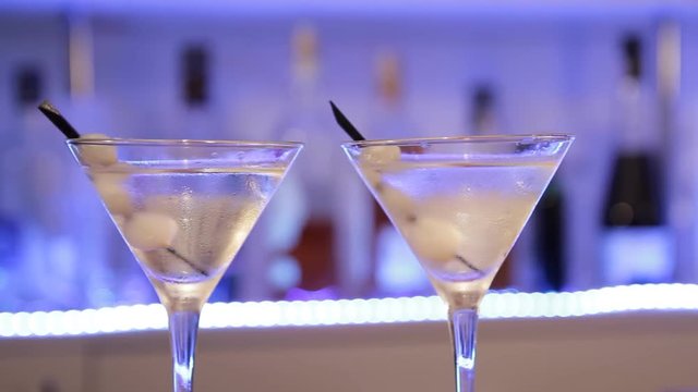 Gin Gibson cocktail. Moving camera from side to side. Alcoholic cocktail with onions, close up.