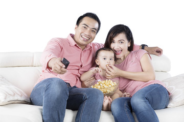 Young parents and daughter watching TV