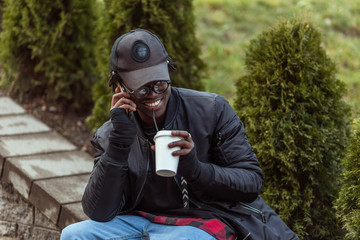 Portrait of a happy african american man on glasses sitting on s