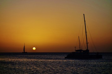 Sunset over a sailboat and the Caribbean Sea in Aruba