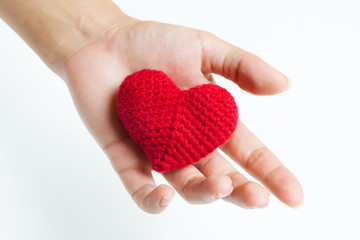 Fototapeta premium Woman hand holding red crocheted heart. Valentine's Day. Symbol of love.