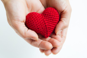 Woman hands holding red crocheted heart. Valentine's Day. Symbol of love.
