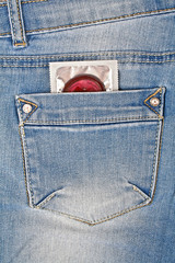 Colored condom in a blue jeans pocket
