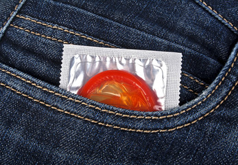 Colored condom in a blue jeans pocket