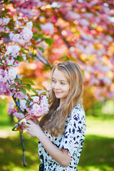 Beautiful young woman in blooming spring park