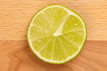 Closeup of lime slice on wooden background