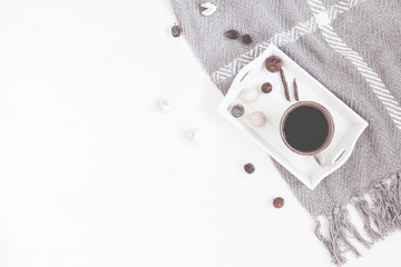 Cozy composition with cup of coffee, tray, blanket. Flat lay, top view