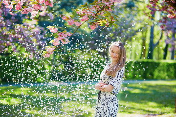 Beautiful young woman in blooming spring park