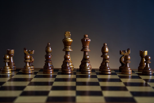 chessboard with black wooden figures, chess with a dark color gradient background