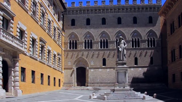 Italy, Tuscany, Siena, Banca Monte dei Paschi di Siena, Palazzo Salimbeni with a statue of the canon Sallustion Bandini